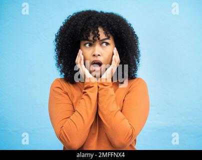 Wow, surprise et idée avec une femme noire en état de choc debout sur un fond bleu en studio. OMG, confus et de penser avec une jeune femme attrayante Banque D'Images