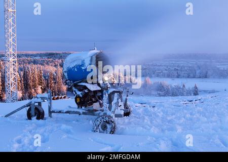 UMEA, SUÈDE, LE 20 DÉCEMBRE 2014. Équipement de fabrication de neige et de pistolet à neige en action. Vue depuis la pente. Utilisation éditoriale. Banque D'Images