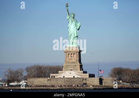 Un drapeau des États-Unis en Berne à la Statue de la liberté, mardi 24 janvier 2023, à New York, en l'honneur des victimes de fusillades de masse au Star Ballroom Dance Studio à Monterey Park, Calif. Banque D'Images