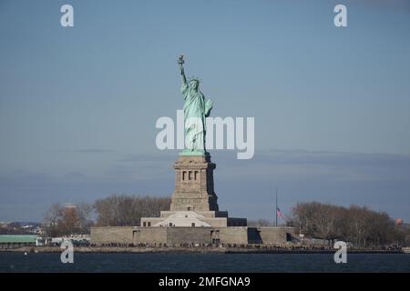 Un drapeau des États-Unis en Berne à la Statue de la liberté, mardi 24 janvier 2023, à New York, en l'honneur des victimes de fusillades de masse au Star Ballroom Dance Studio à Monterey Park, Calif. Banque D'Images