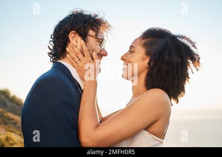 Mariage, amour et couple interracial en montagne pour la cérémonie du mariage, l'engagement et la célébration par la mer. Vacances romantiques, heureux et mariée et marié Banque D'Images