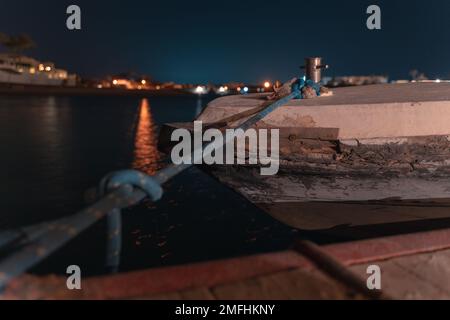 Une exposition longue durée d'un bateau dans la lagune d'El Gouna sur une vue de la ville illuminée la nuit Banque D'Images