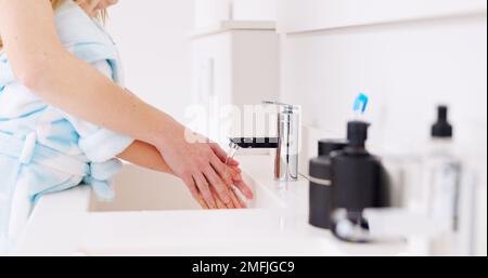 Nettoyage, la mère et l'enfant se lavant les mains dans la salle de bains de leur maison pour la santé ensemble. Fille apprenant à nettoyer les mains avec l'aide de maman, l'eau Banque D'Images