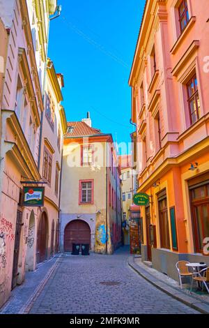 PRAGUE, TCHÉQUIE - 11 MARS 2022: L'étroite rue au coeur de Mala Strana (vieille ville) avec des signes de restaurants, sur 11 mars à Prague, Tchéquie Banque D'Images