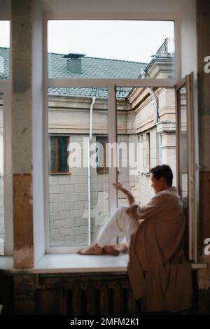 Portrait de belle femme mûre reposant par la fenêtre - foyer sélectif. Banque D'Images
