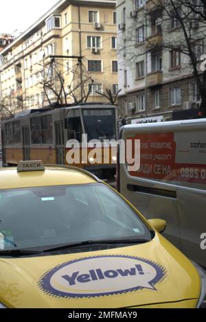 Une photo verticale d'un tramway passant par une rue étroite avec des bâtiments dans le centre-ville, scène de rue Banque D'Images