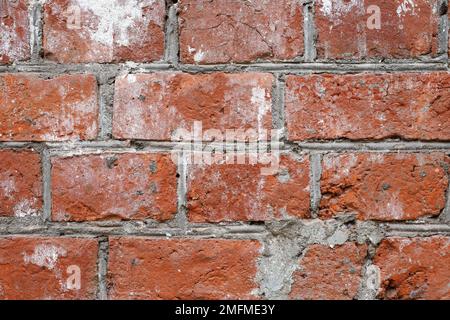 Texture de mur en brique rouge. Ancienne façade d'un bâtiment avec joints en béton, arrière-plan vintage Banque D'Images