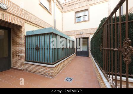 Portail d'un bâtiment avec portes métalliques au rez-de-chaussée et accès aux maisons avec portes noires Banque D'Images