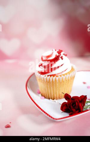 Saint-Valentin tourbillons de cupcake avec glaçage blanc rouge et roses | fond de dessert de jour de Saint-Valentin, foyer sélectif Banque D'Images