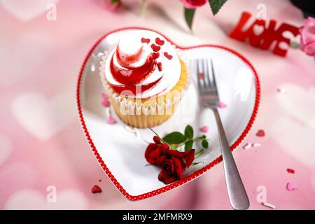 Saint-Valentin tourbillons de cupcake avec glaçage blanc rouge et roses | fond de dessert de jour de Saint-Valentin, foyer sélectif Banque D'Images