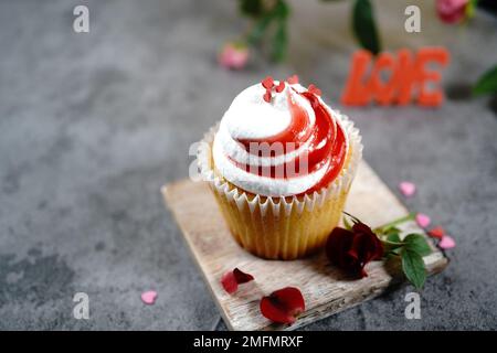 Saint-Valentin tourbillons de cupcake avec glaçage blanc rouge et roses | fond de dessert de jour de Saint-Valentin, foyer sélectif Banque D'Images