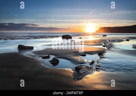 La vue Sud-est au-dessus de Robin Hood's Bay vers Ravenscar à Sunrise, North Yorkshire, Royaume-Uni Banque D'Images