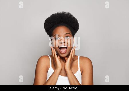 Portrait de joli attrayant surpris modèle femelle avec maintient la bouche largement ouverte, étant étonné avec quelque chose. Banque D'Images