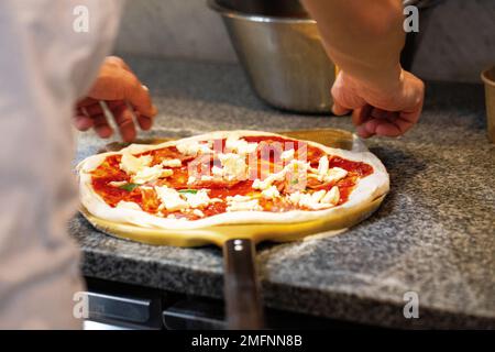 Préparation de délicieuses pizzas traditionnelles italiennes. Banque D'Images