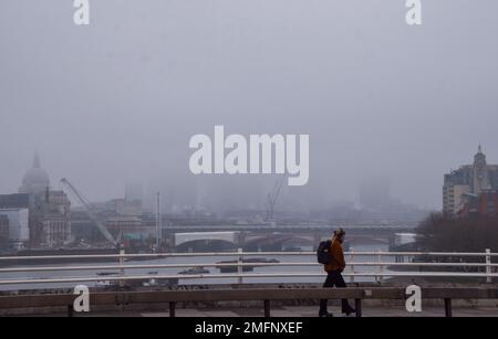 Londres, Royaume-Uni. 25th janvier 2023. Un piéton marche le long du pont Waterloo en passant devant un horizon obcertain de la ville de Londres alors que du brouillard glacial recouvre la capitale. Credit: Vuk Valcic/Alamy Live News Banque D'Images