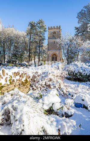 Début hiver neige à l'église de St John l'évangéliste dans le village Cotswold d'Elkstone, Gloucestershire, Angleterre Royaume-Uni Banque D'Images