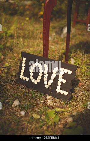 Une verticale d'une petite bannière avec le mot « Love » composé de petits coeurs pour la cérémonie de mariage Banque D'Images