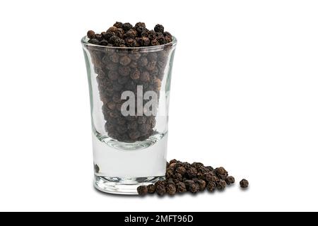 Vue latérale de la pile de graines de poivre noir et de graines de poivrons noirs dans un petit verre sur fond blanc avec un chemin d'écrêtage Banque D'Images