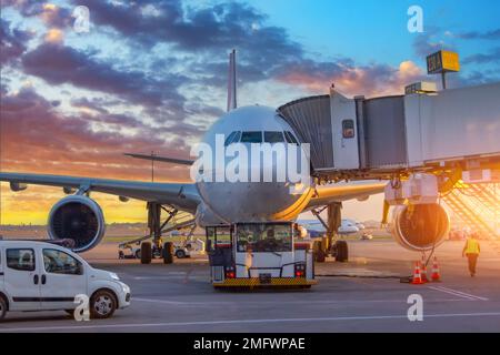 L'avion effectue une opération de repoussée à l'aéroport. Service d'avion pour les vols avant le départ dans la soirée au coucher du soleil Banque D'Images