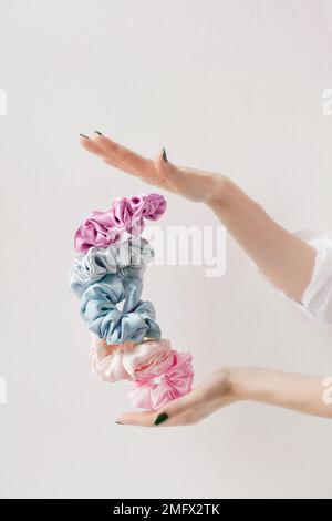 Soie colorée Scrunchies sur les femmes main.outils équilibre. Accessoires de coiffure. Serre-tête ou serre-tête élastiques pour filles. copier l'espace Banque D'Images