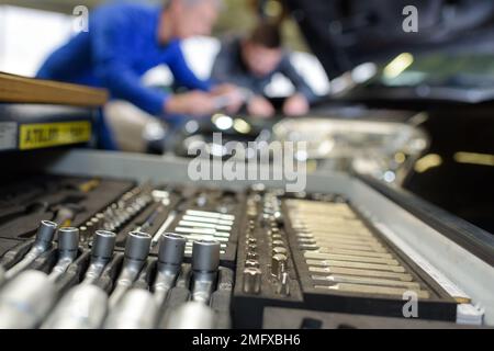 Avec moniteur étudiant la réparation d'une voiture pendant l'apprentissage Banque D'Images
