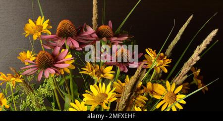 Un bouquet de fleurs recueillies dans la nature dans un vase en verre simple isolé sur fond noir. Banque D'Images