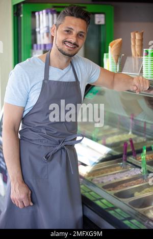 vendeur souriant à la caméra Banque D'Images