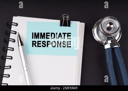Concept médical. Sur une surface noire, un stéthoscope, un carnet, un stylo et un autocollant bleu avec l'inscription - RÉPONSE IMMÉDIATE Banque D'Images