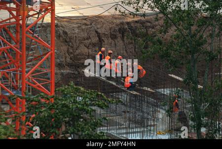 l'équipe des ouvriers du bâtiment se trouve dans une rangée dans la fosse du chantier de construction Banque D'Images