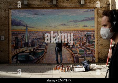 Australian street artist James Cochran, also known as Jimmy C, puts the finishing touches to his London cityscape mural on a Network Rail wall by Blackfriars Station, in London, Monday, Oct. 5, 2020. It is the first time Cochran has painted a cityscape as a piece of street art outside of his studio and has taken six days to paint working through wet and rainy conditions. (AP Photo/Matt Dunham)
