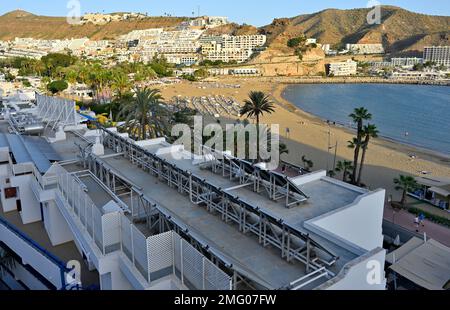 Panneaux thermaux solaires sur le toit de l'hôtel surplombant la plage de sable de Puerto Rico et le front de mer, Arguineguín, Gran Canaria Banque D'Images