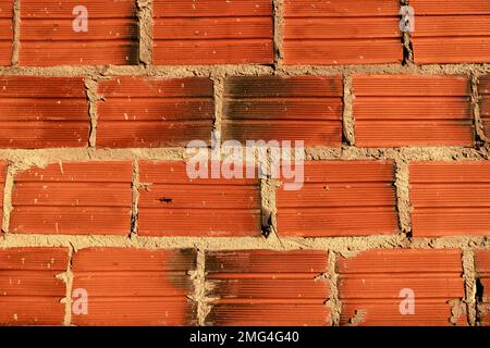 Mur rustique de blocs rouges et de béton. Banque D'Images