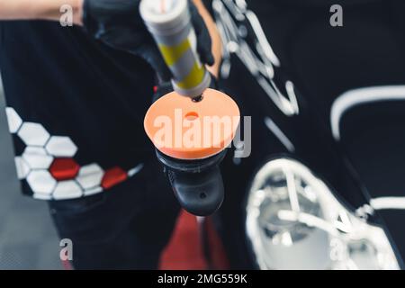 Gros plan de l'outil tampon professionnel en cours de préparation pour polir la peinture fraîche de la voiture. Processus d'habillage des voitures. Prise de vue horizontale en intérieur . Photo de haute qualité Banque D'Images