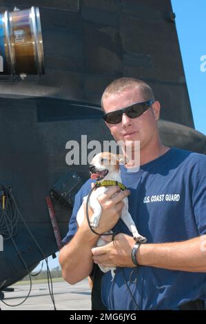 Personnel de la Garde côtière - divers - 26-HK-90-180. Coast Guardsman tenant le chien à l'extérieur. Ouragan Katrina Banque D'Images