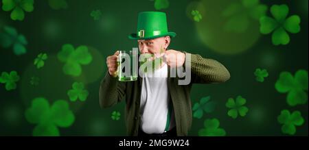 Homme barbu avec bière sur fond vert foncé. Bannière pour St. Patrick Banque D'Images