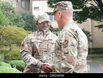 Le Sgt. Jerry Dunn, Chef de commandement de l'escadre du transport aérien 374th, salue le Lieutenant général James Jacobson, commandant adjoint de la Force aérienne du Pacifique, lors de sa visite au quartier général de l'escadre du transport aérien 374th, à la base aérienne de Yokota, au Japon, le 22 août 2022. Au cours de sa visite, Jacobson a rencontré des aviateurs et a discuté des capacités stratégiques, du rythme des opérations et des plans futurs de Yokota. Banque D'Images