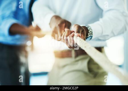 Tirer. des hommes d'affaires méconnaissables tirent sur une corde pendant une période de guerre. Banque D'Images