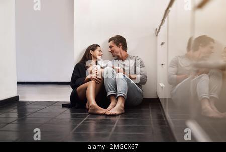 Tous les jours ensemble est le meilleur jour de ma vie. un jeune couple affectueux assis au sol de la cuisine. Banque D'Images