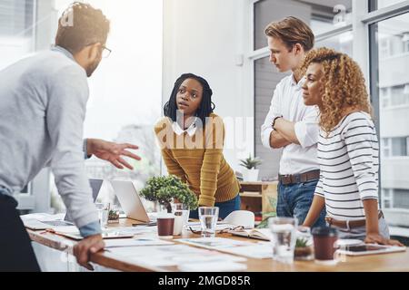 En vous assurant que tout est sur la même page. un groupe d'hommes d'affaires ayant une séance de brainstorming. Banque D'Images