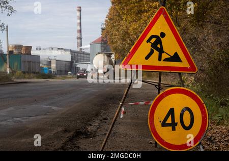 Panneau de limite de vitesse en raison d'un travail sur route indiquant une vitesse maximale de 40 kilomètres par heure. Tournez le panneau de signalisation au sol. Banque D'Images