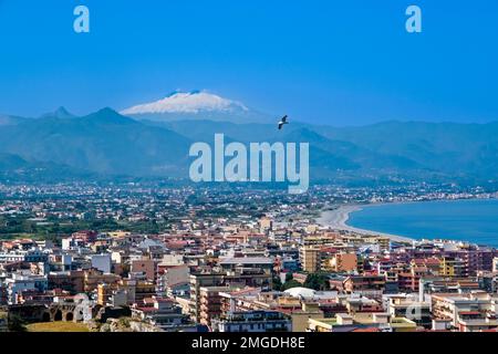 Vue aérienne de la ville de Milazzo, située au bord de la mer, et du volcan Etna, Mongibello, au loin. Banque D'Images