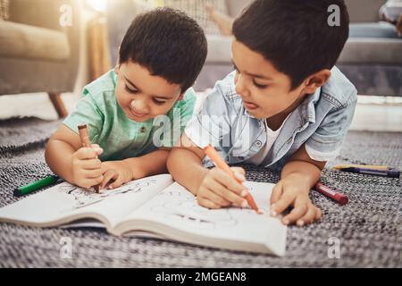 Enfants, frères et dessin tout en apprenant sur le sol à la maison, se détendre et heureux tout en liant. Enfants, art et croquis dans le carnet par frères et sœurs ayant le plaisir Banque D'Images