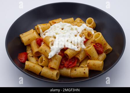 Mezze Maniche Rigate, pâtes italiennes, avec tomates cerises et fromage stracciatella. Banque D'Images