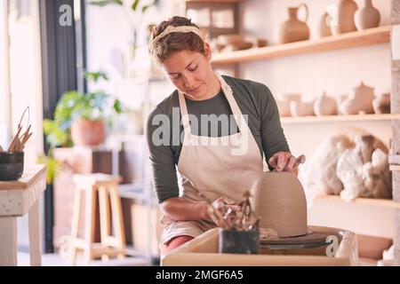 La roue de poterie, la moule et la femme conçoivent la sculpture, le procédé de fabrication de l'argile ou le produit d'art. Magasin de vente au détail créatif, processus d'artisanat et démarrage petit Banque D'Images