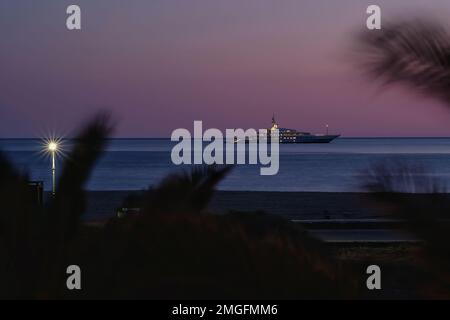 IOS, Grèce - 3 juin 2021 : vue sur un yacht de luxe à la célèbre plage de Mylopotas à iOS Grèce et un coucher de soleil violet Banque D'Images