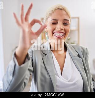 Portrait, langue et emoji avec une femme noire d'affaires qui se presse dans son bureau au travail pour faire un geste parfait signe de main. Visage, motivation et succes avec Banque D'Images