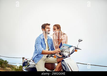 Allons dans un endroit qui n'a jamais été. un couple affectueux regardant une carte pendant qu'il est en moto. Banque D'Images