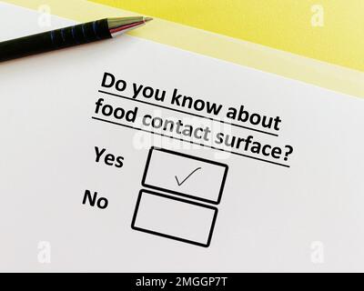 Une personne répond à une question sur la fabrication de produits alimentaires. Il connaît la surface en contact avec les aliments. Banque D'Images