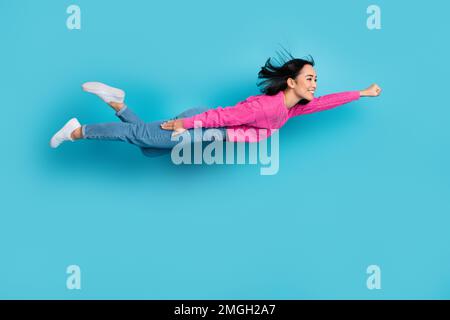 Photo pleine longueur de l'adorable femme utile porter le pull-over rose volant air huring aider isolé couleur bleu arrière-plan Banque D'Images