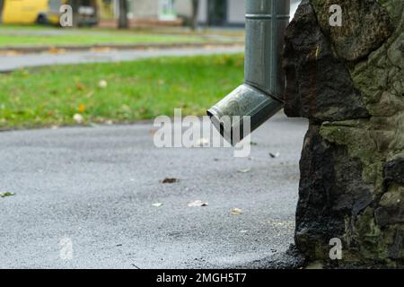 Descente de gouttière près du côté d'une maison, vue latérale. Bas de la goulotte de descente. Banque D'Images